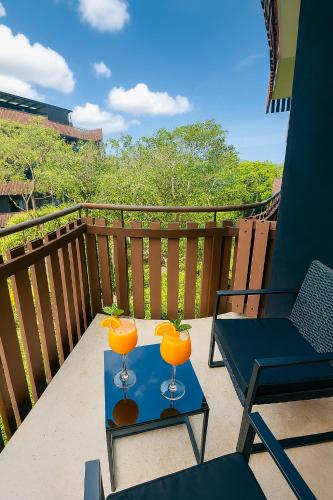 a balcony with a table with two orange glasses on it at Jungle Guardian - Rooftop Pool & Beach Club in Zona Hotelera Tulum in Tulum