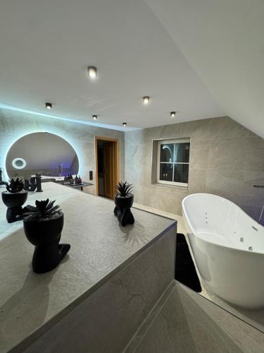a large bathroom with a tub and a sink at Ays-SPA, Whirlpool & Sauna in Iserlohn