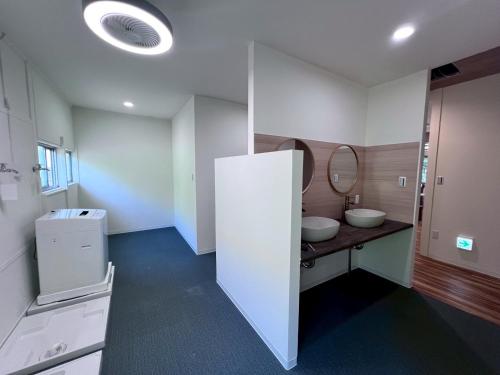 a bathroom with two sinks and a mirror at Hostel あざみ庵よろん in Yoron