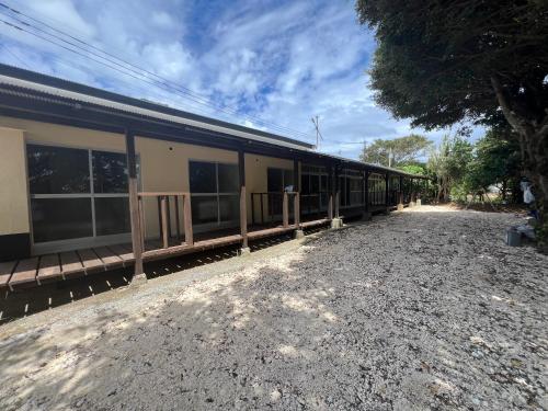 a train is parked next to a building at Hostel あざみ庵よろん in Yoron