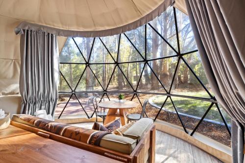 a room with a large window with a couch and a table at BIG4 Yarra Valley Park Lane Holiday Park in Healesville