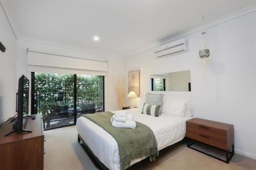 una camera da letto con un letto grande e una televisione di 3BR Family Home - Urban West Footscray Haven a Seddon
