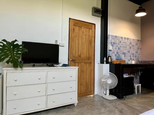 a bedroom with a dresser with a television on it at Nokhook House in Trang