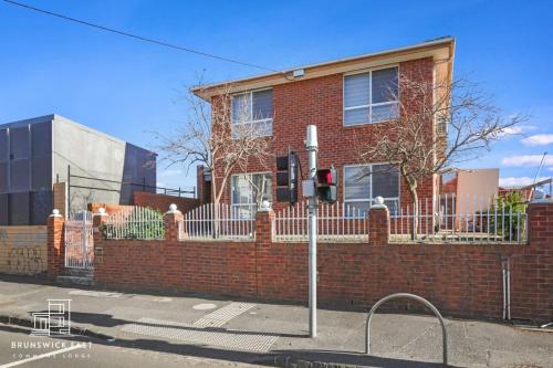 a red brick house with a fence in front of it at 206 Modern King BR with Fast WiFi - Brunswick East in Melbourne