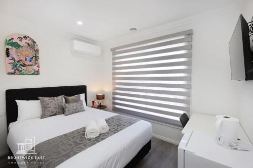 a bedroom with a bed and a large window at 207 Chic Queen BR with Fast WiFi - Brunswick East in Melbourne