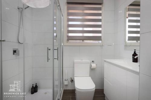 ein Badezimmer mit Toilette und Glasdusche in der Unterkunft 208 Queen BR with Fast WiFi - Brunswick East in Melbourne