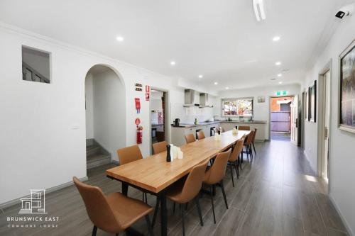 a dining room with a long wooden table and chairs at 205 Modern King BR with Fast WiFi - Brunswick East in Melbourne
