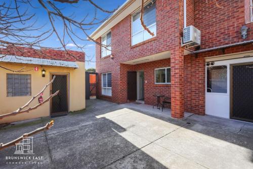 an empty driveway in front of a brick building at 205 Modern King BR with Fast WiFi - Brunswick East in Melbourne
