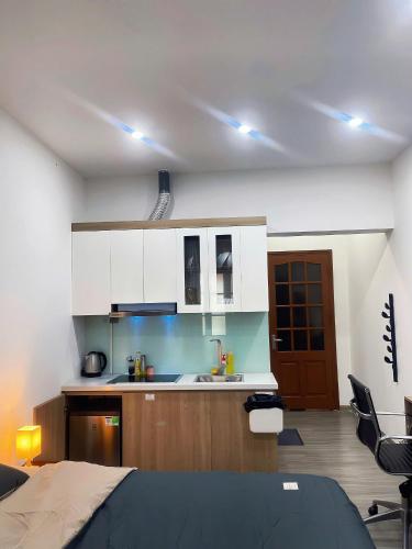 a kitchen with white cabinets and a bed in a room at TV-Netflix STU 302 Near Uncle Ho's Mausoleum in Hanoi
