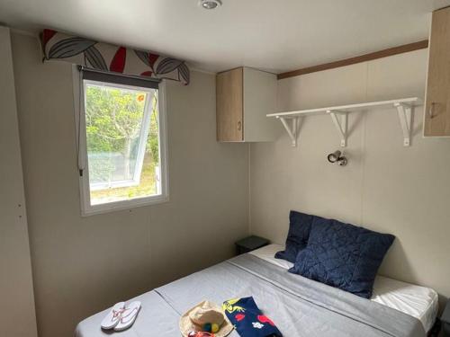 a small bedroom with a bed and a window at Mobil home 6 pers avec terrasse - API-1-52-222 in Saint-Maurice-dʼIbie