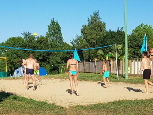 a group of people playing a game of volley ball at Chalet cosy - Vue sur l'étang avec terrasse - API-1-52-288 in Naucelle