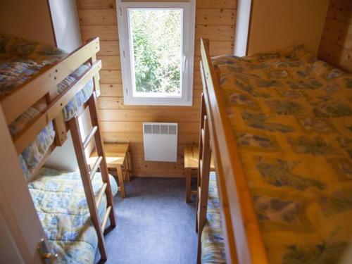 a small room with two bunk beds and a window at Chalet spacieux pour 8 pers - Vue étang - Terrasse - API-1-52-224 in Naucelle