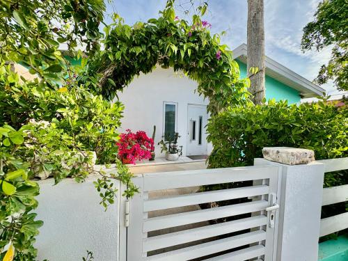 a white fence in front of a house with flowers at Fantastic Private Tropical Villa in Palm Beach with Breakfast in Palm-Eagle Beach