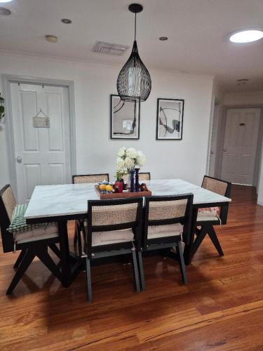 a dining room table and chairs with a table and a pendant at Venus Place 1 in Sydenham