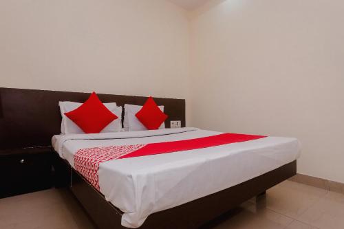 a bedroom with a large bed with red pillows at Hotel O Diplomat in Sopāra