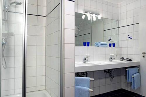 a bathroom with a shower and a sink and a mirror at Kaiserhof 302 in Wangerooge