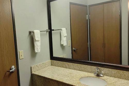 a bathroom with a sink and a large mirror at University Inn in Boiling Springs