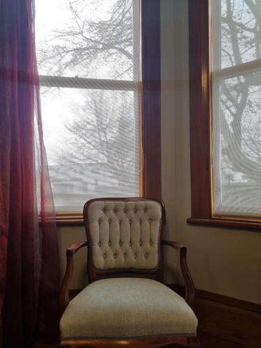 a chair sitting in front of a window at Villa Charm on Claudelands in Hamilton