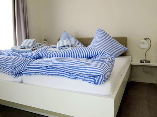 万根沃格Bootshaus Achterstag的一张带蓝色和白色条纹毯子和枕头的床