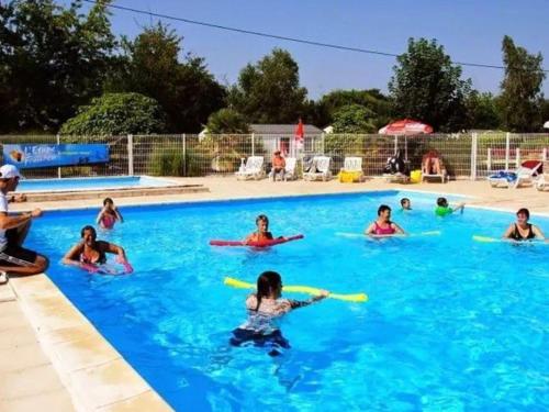 a group of children playing in a swimming pool at Mobil home 8 pers avec terrasse à Saint-Sornin - API-1-52-461 in Saint-Sornin
