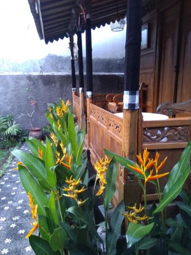 an outdoor kitchen with orange flowers in a garden at Buratwangi Joglo House in Kerobokan