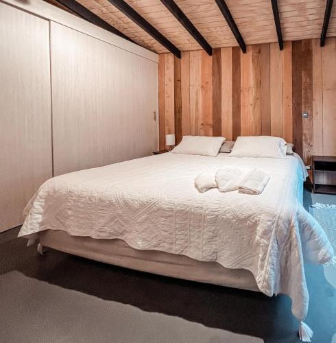 a bedroom with a large bed with towels on it at suite campestre con terraza in Puerto Varas