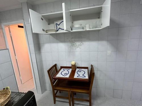 Una pequeña mesa y silla en una cocina con mostrador. en Apê na Enseada - Ar, Wi-Fi, garagem e praia a pé!, en Guarujá