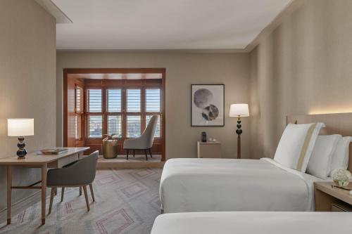 a hotel room with a large bed and a desk at Jumeirah Jabal Omar Makkah in Makkah
