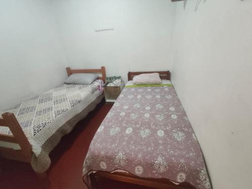 two beds sitting next to each other in a room at Hostal Venecia in Arica