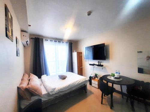 a room with a bed and a table and a window at JJL Suites for DAILY RENTAL in Suba