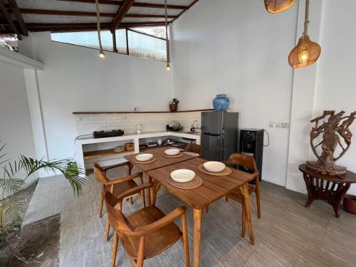 Una cocina con una mesa y sillas de madera en una habitación. en Villa AnTeak, en Gili Air
