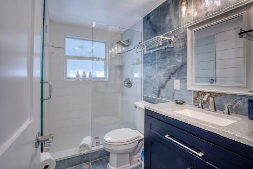 a bathroom with a shower and a toilet and a sink at Restorative Escape-Moonlit Waters-Steps to beach. in Holmes Beach