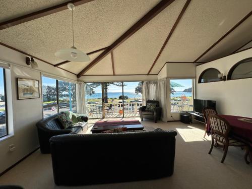 a living room with a couch and a table at Classic Kiwi Beachfront Bach in Mount Maunganui