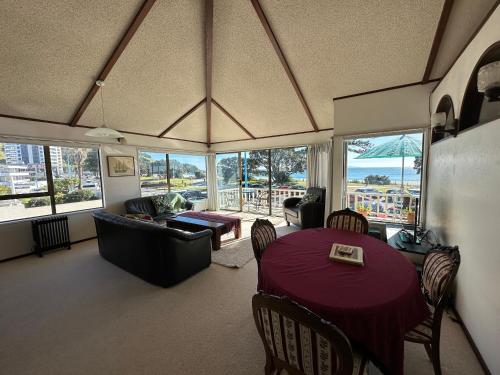 a living room with a table and a couch at Classic Kiwi Beachfront Bach in Mount Maunganui