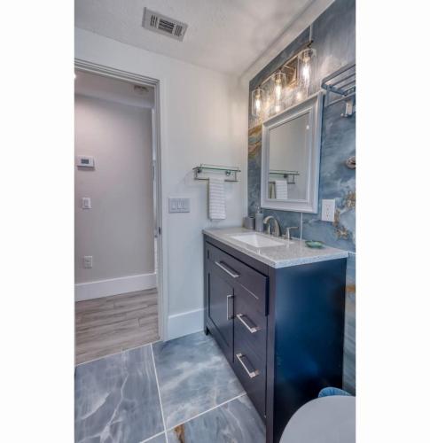 a bathroom with a sink and a mirror at Tranquility Meets Style-Walk to beach-prvt pool. in Holmes Beach