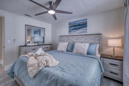 a bedroom with a bed and a ceiling fan at Tranquility Meets Style-Walk to beach-prvt pool. in Holmes Beach