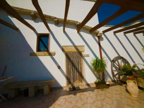 a blue and white wall with a window and a wheel at Masseria Cinti in Bagnolo del Salento