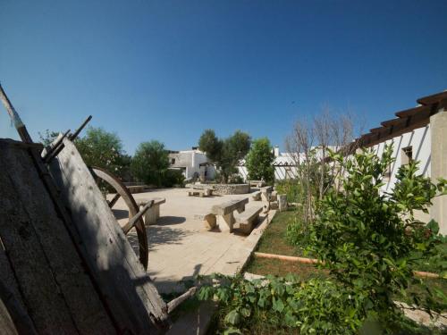 a garden with a bunch of benches and a building at Masseria Cinti in Bagnolo del Salento