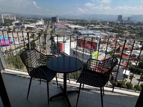 a table and chairs on a balcony with a view of a city at Hermoso Loft frente a Plaza Mayor en León Gto in Miravalle