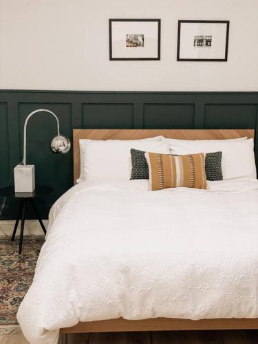 a bedroom with a large white bed with a green headboard at Garden Oasis 3BR 15 min FIFA World Cup MetLife Std in Harrison