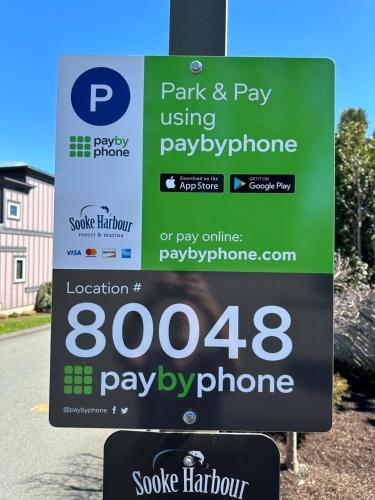 a sign for a pay phone on the side of a road at Sooke Harbour Penthouse in Sooke