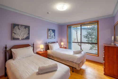 ManyanaにあるHasta Manyana ocean front villaのベッド2台と窓のある寝室