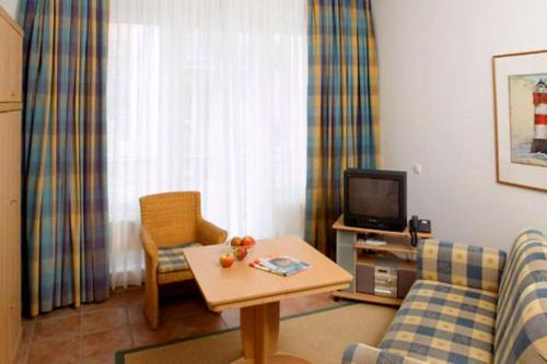 a living room with a couch and a table and a tv at Kaiserhof 010 in Wangerooge