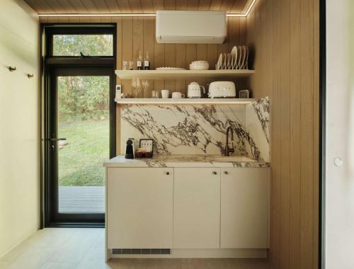 a kitchen with white cabinets and a sink at Luxury Mirror Home In Byron Bay in Byron Bay