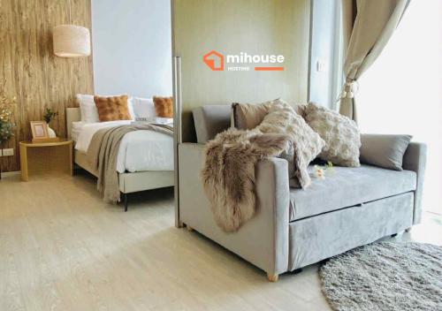 een woonkamer met een bank en een bed bij veranda Residence in Na Jomtien