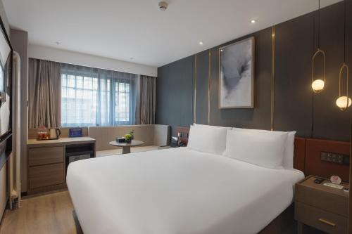 a large white bed in a hotel room at Orange Beijing Yansha Landmark Hotel in Beijing