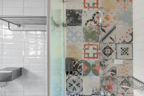 a bathroom with a shower with a tile wall at Sunset Mu Style Inn in Xiaoliuqiu