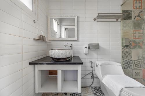 a white bathroom with a sink and a mirror at Sunset Mu Style Inn in Xiaoliuqiu