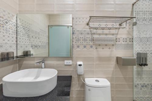 a bathroom with a white sink and a toilet at Sunset Mu Style Inn in Xiaoliuqiu