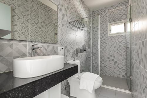 a bathroom with a sink and a toilet and a shower at Sunset Mu Style Inn in Xiaoliuqiu
